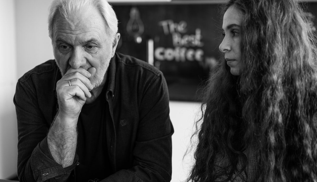 An older man and a younger woman sat together looking concerned. The younger girl being executor of her parents' will.