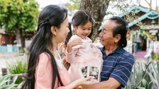 Grandparents cuddling a young grandchild having a nice time. Best holiday destinations granchildren - Silver Magazine www.silvermagazine.co.uk