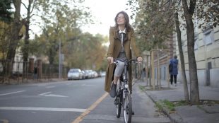 woman in work clothes cycling on a road