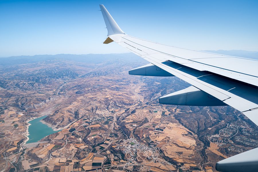 Wing of an airplane flying over a holiday island, Cyprus. Travel article about winter sun in Cyprus on Silver Magazine www.silvermagazine.co.uk