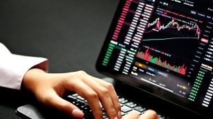 Image shows a laptop with investment screen, green and red columns etc. demo accounts for investment practice - article Silver Magazine www.silvermagazine.co.uk