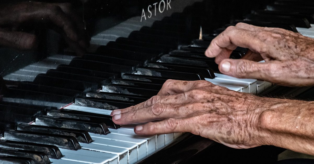 Elderly person playing piano for music article on Silver Magazine www.silvermagazine.co.uk