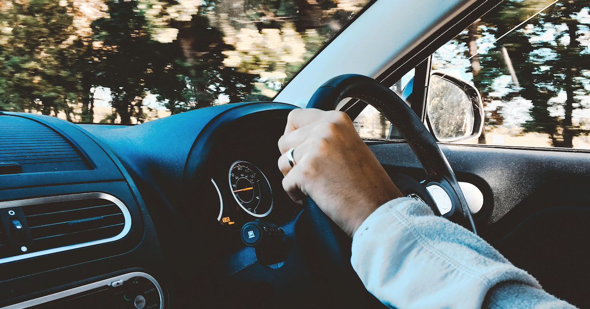hands on a car steering wheel moving along