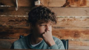 Sad looking teenage boy staring into the distance. how to support teen mental health article Silver Magazine www.silvermagazine.co.uk