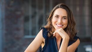Confident mature woman, smiling towards the camera. Invest in yourself for more weatlh and work - Silver Magazine