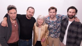 Image shows lineup of stars for Jilly Cooper's Rivals in press shot. Left to right: Alex Hassell, Danny Dyer, Dame Jilly Cooper, David Tennant, Aidan Turner