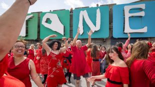 An action shot of people wearing red dresses dancing.