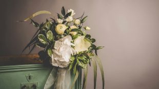 Showing beautiful funeral flowers on a wooden box, minimalist vibes. legal aspects of funeral planning article Silver Magazine www.silvermagazine.co.uk