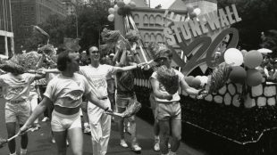 A black and white image of a LGBTQ Pride parade, with people celebrating New York Pride Parade, 1989, 20th anniversary of Stonewall, photograph by Joseph T. Barna