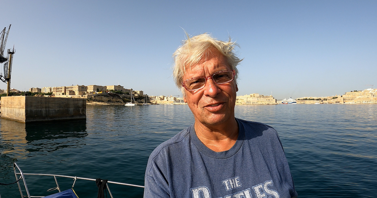 Portrait of Stephen Payne with sea streching out behind him.