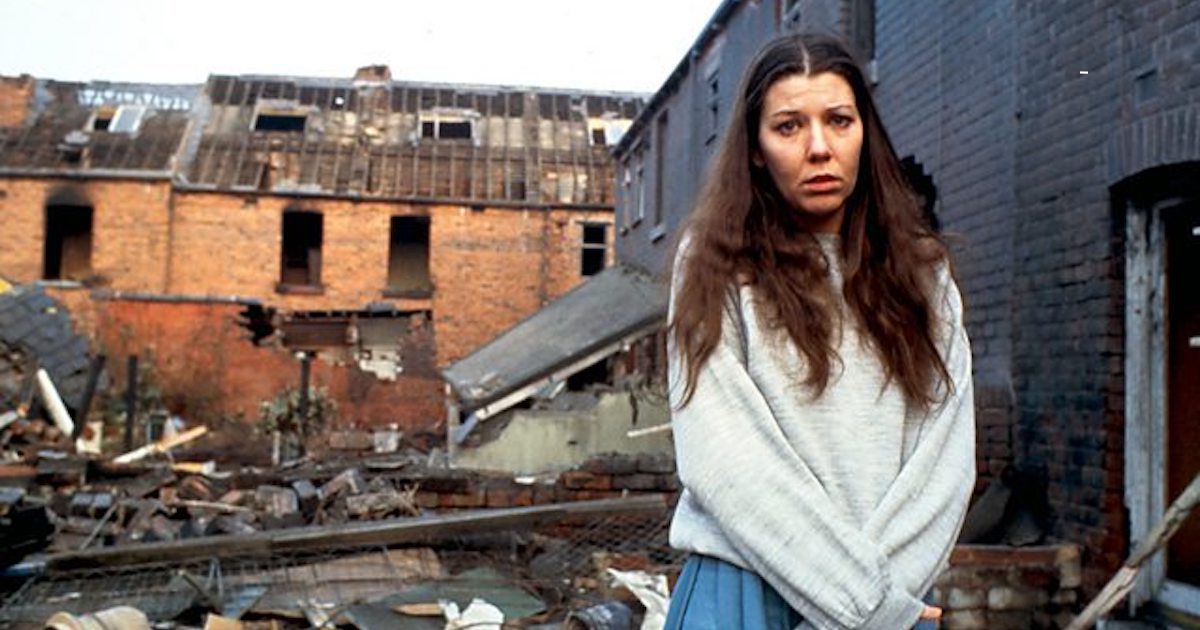 A young woman stands looking terrified in front of buildings and rubble destroyed by nuclear war. Threads nuclear war film is coming back to BBC One