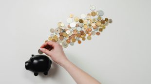 someone putting money into a piggy bank