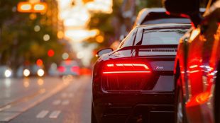 Shows rear of R8 with brake light lit up, about to pull into sunset traffic. signs your car needs brake repairs article Silver Magazine www.silvermagazine.co.uk