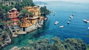 Shows beautiful cove in Italy, lots of boats, beautiful sea, houses built into the hillside etc. Travel on a budget italy - Silver Magazine www.silvermagazine.co.uk