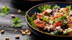 Warm baked carrots and beetroot salad with feta cheese and roasted hazelnuts.