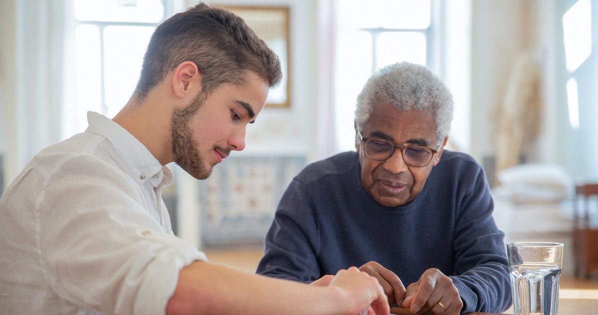 young man helping older man in nursing home - article for Silver www.silvermagazine.co.uk